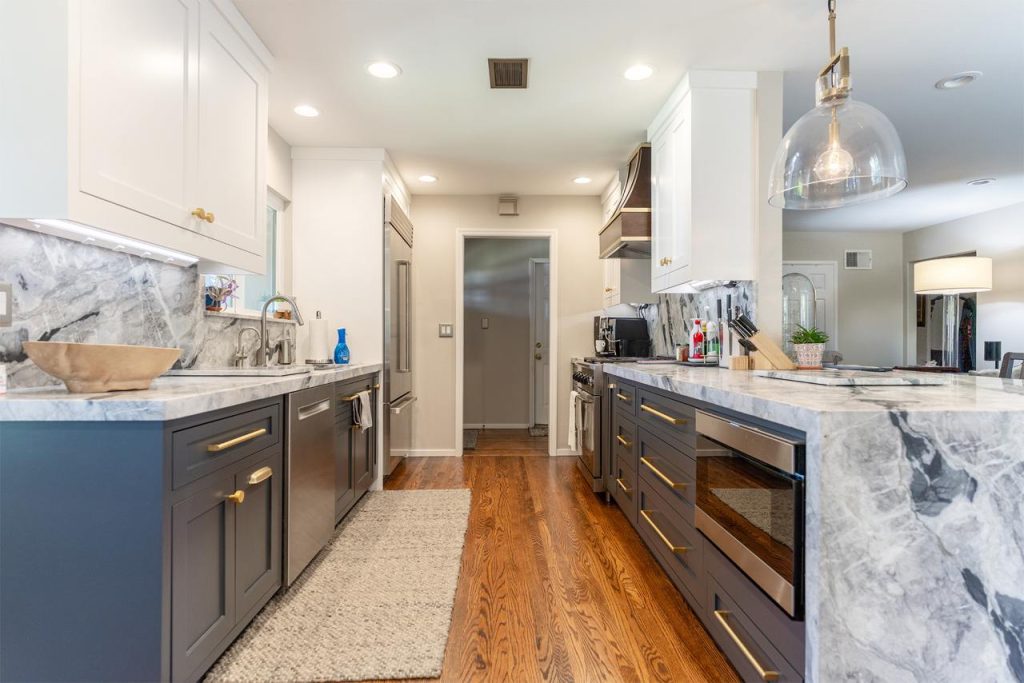 Contemporary kitchen remodel Honolulu project featuring dark blue cabinetry with white quartz backsplash and hardwood floors