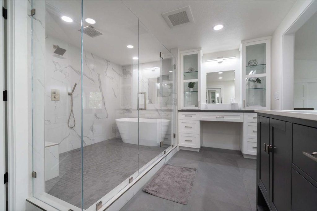 Elegant bathroom design with marble countertops featuring dual vanities and classic white cabinetry