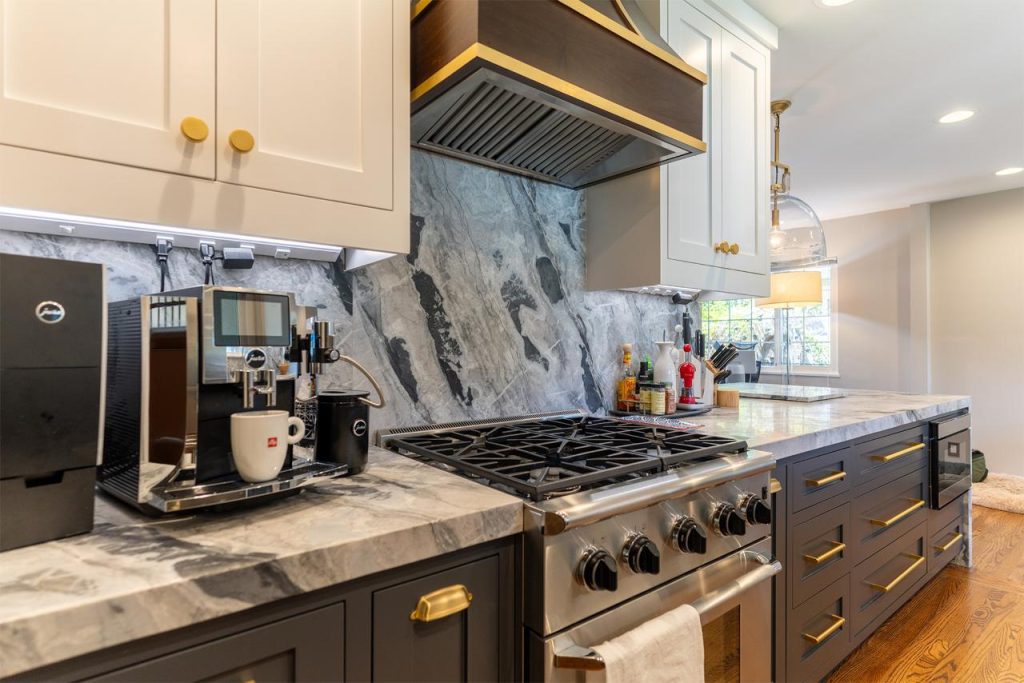 Honolulu kitchen remodel featuring dark cabinets, a marble backsplash, and brass hardware accents.