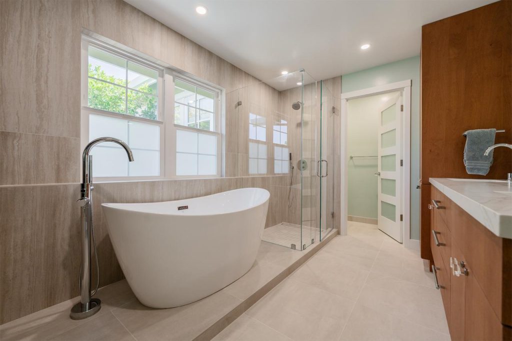 Luxury spa-inspired bathroom remodel by remodeling contractors in Honolulu featuring a freestanding soaking tub and frameless glass shower enclosure